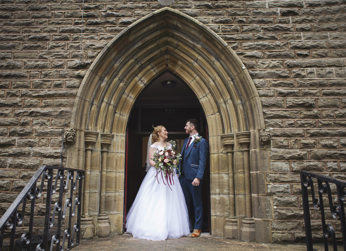 Newlyweds standing in a Church archway